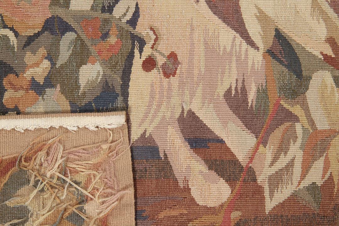 Een handgeweven tapijt in Aubusson-stijl uit China met een beige achtergrond en een picturaal tafereel van dieren en bomen.