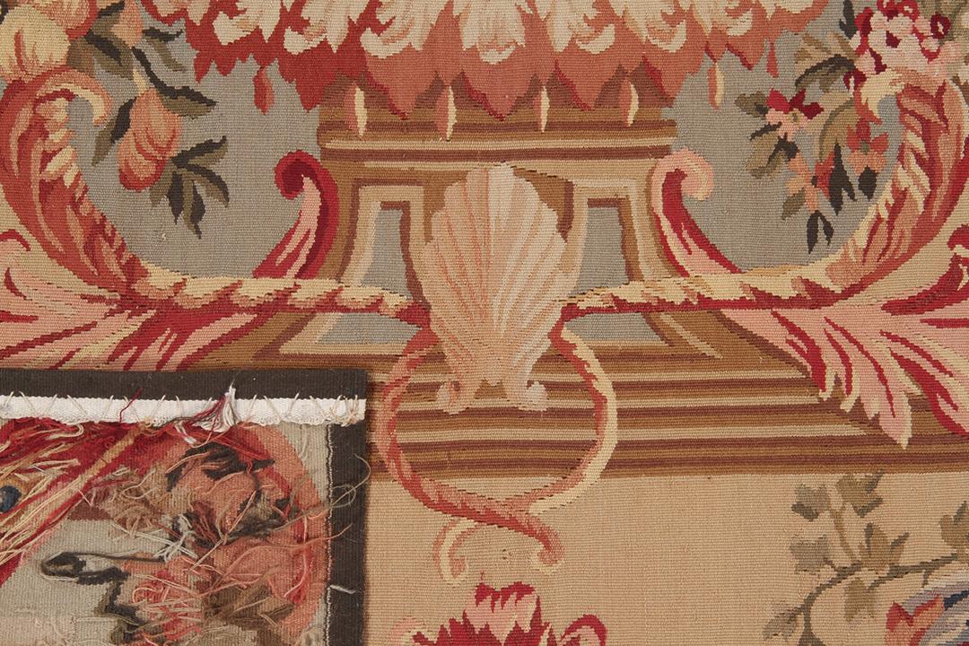 Håndvævet tæppe i Aubusson-stil med blomstermotiver og en central figur i beige og rød