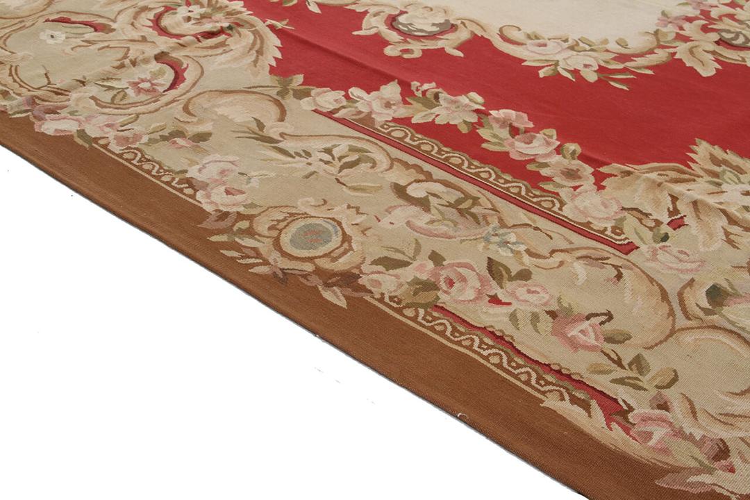 Håndvævet tæppe i Aubusson-stil med en blomstret medaljon i rød og creme, fremstillet i Kina.