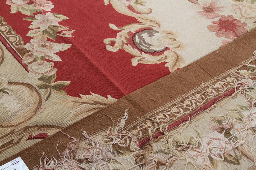 Håndvævet tæppe i Aubusson-stil med en blomstret medaljon i rød og creme, fremstillet i Kina.