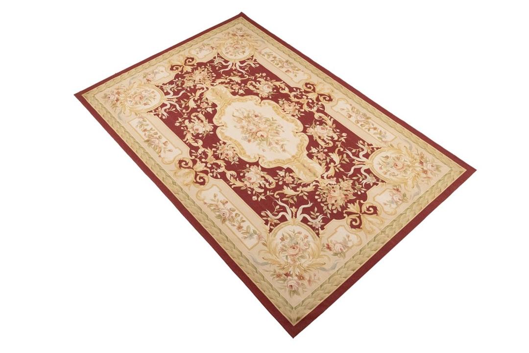 Hand-woven floral rug with a red field and decorative border from China
