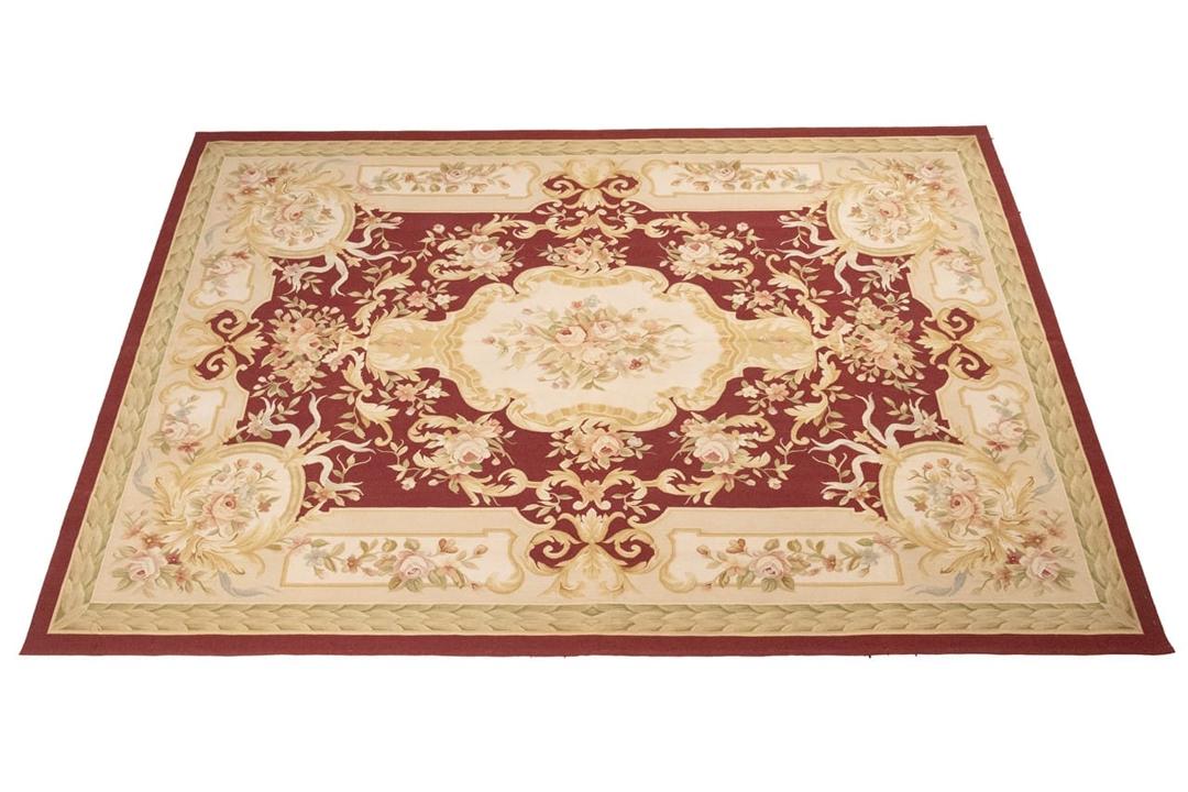Hand-woven floral rug with a red field and decorative border from China