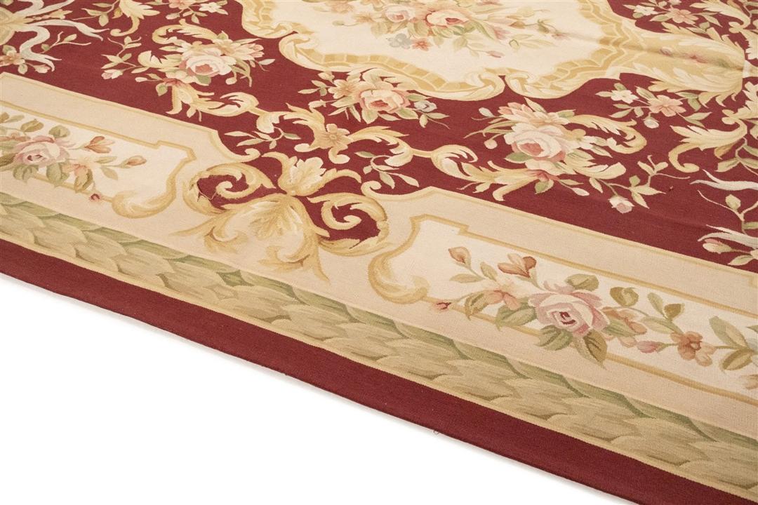Hand-woven floral rug with a red field and decorative border from China