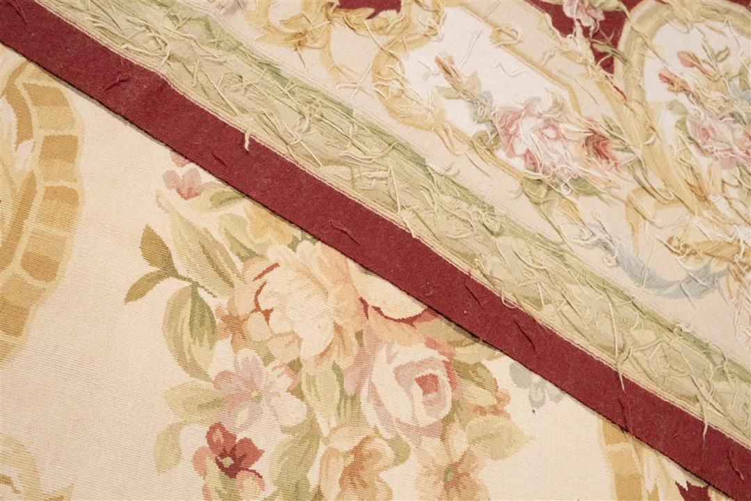 Hand-woven floral rug with a red field and decorative border from China