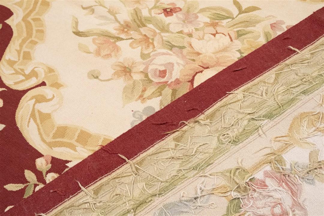 Hand-woven floral rug with a red field and decorative border from China