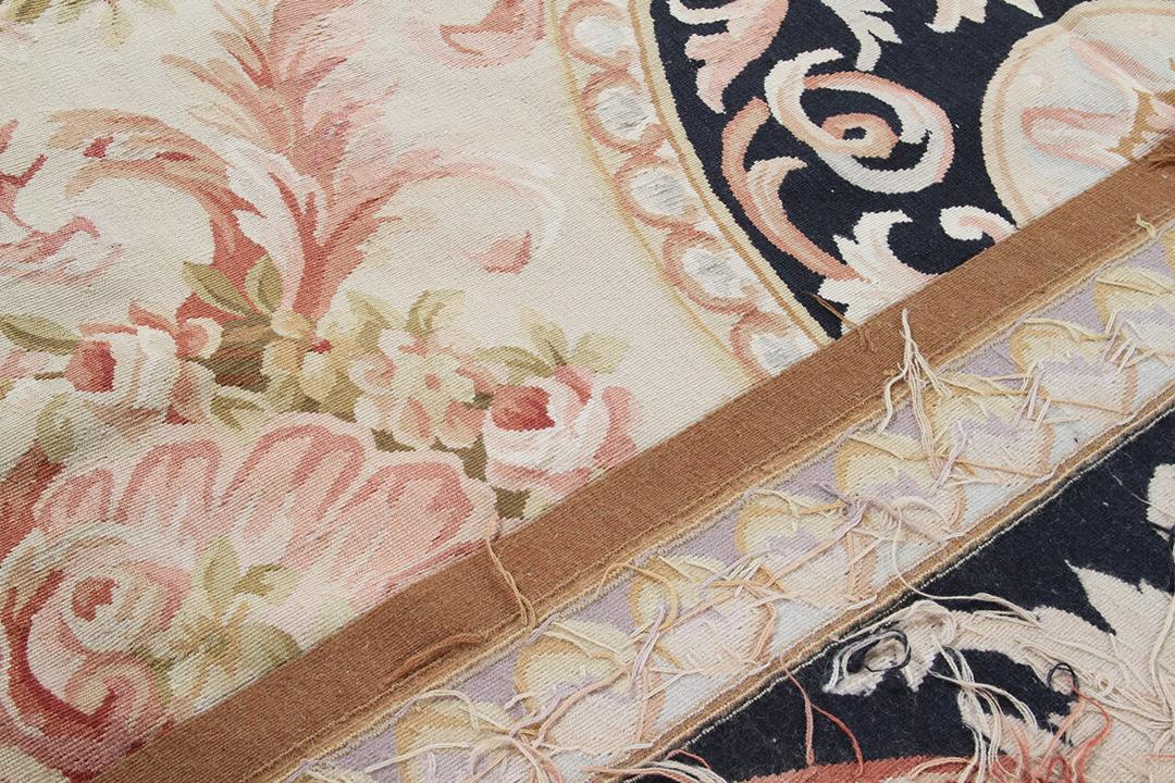 Et rektangulært tæppe i Aubusson-stil med indviklede blomstermotiver og mørkeblå og beige toner fra Kina.