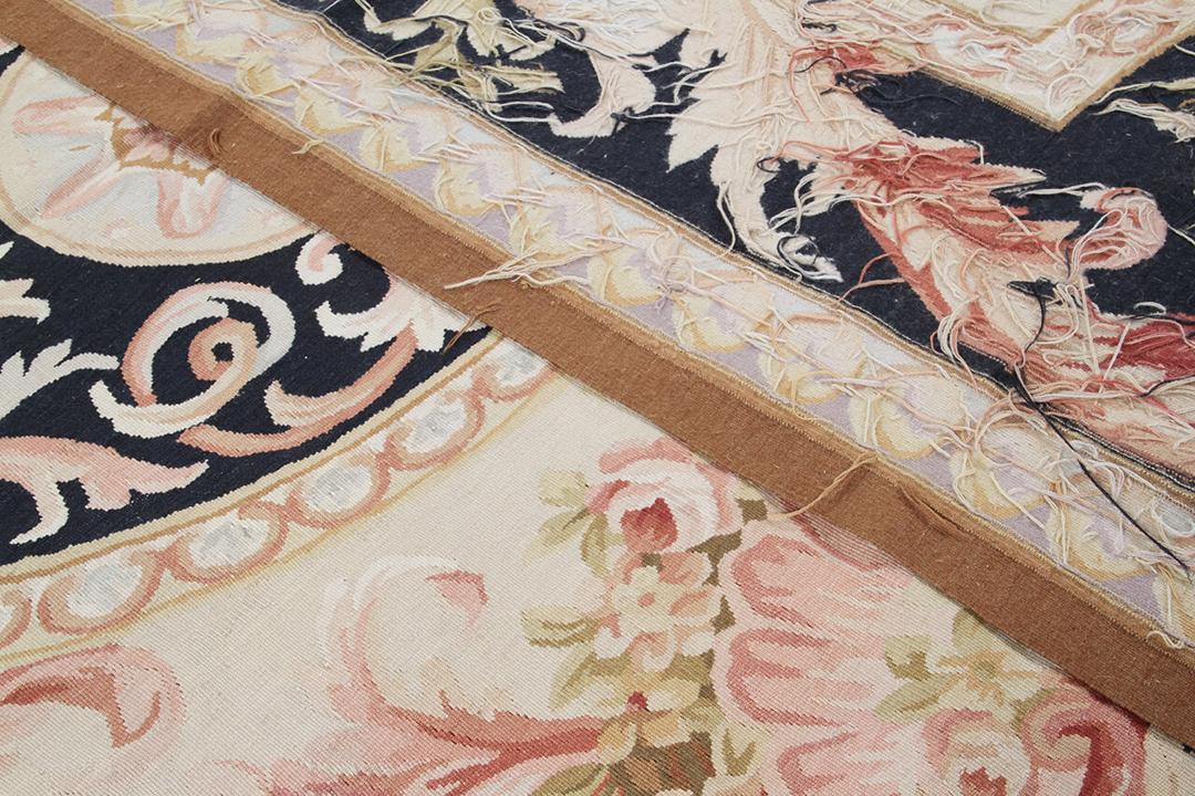 Et rektangulært tæppe i Aubusson-stil med indviklede blomstermotiver og mørkeblå og beige toner fra Kina.