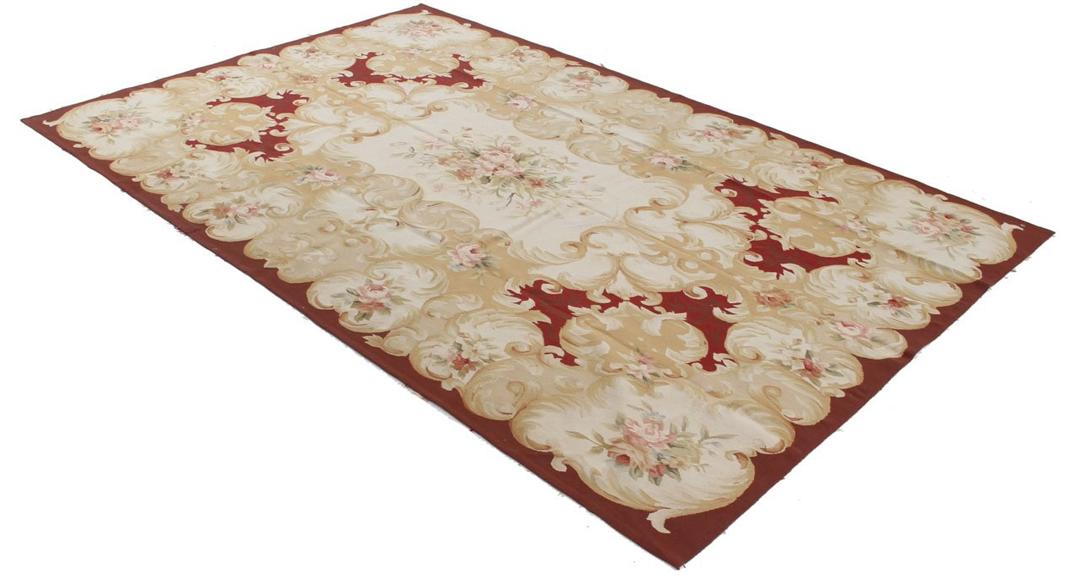Et rektangulært, håndvævet tæppe fra Kina med et rødt og beige blomstermedaillon-design.