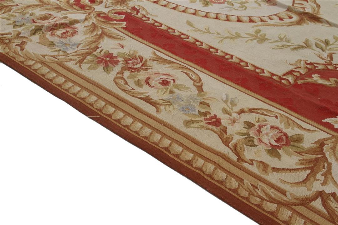 Et rektangulært, håndvævet tæppe fra Kina med et rødt og beige blomstermedaillon-design.