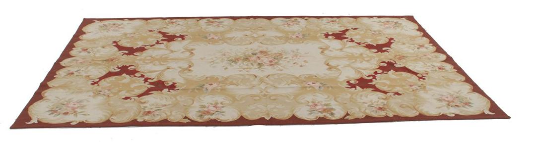 Et rektangulært håndvævet Kilim-tæppe fra Kina med et blomstermønster i rødt og beige.