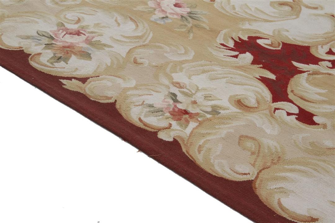 Et rektangulært håndvævet Kilim-tæppe fra Kina med et blomstermønster i rødt og beige.
