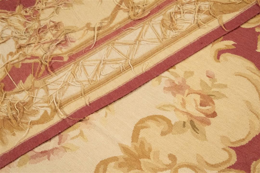Et kvadratisk håndvævet tæppe i Aubusson-stil fra Kina med blomstermotiver i rød og beige