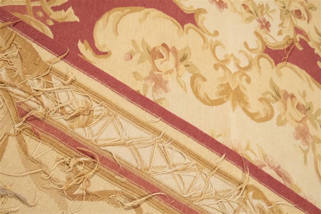 Et kvadratisk håndvævet tæppe i Aubusson-stil fra Kina med blomstermotiver i rød og beige