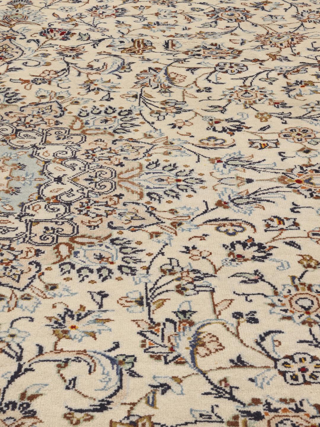Et stort rektangulært Keshan-tæppe fra Mellemøsten med en blomstermedaljon på en beige baggrund.