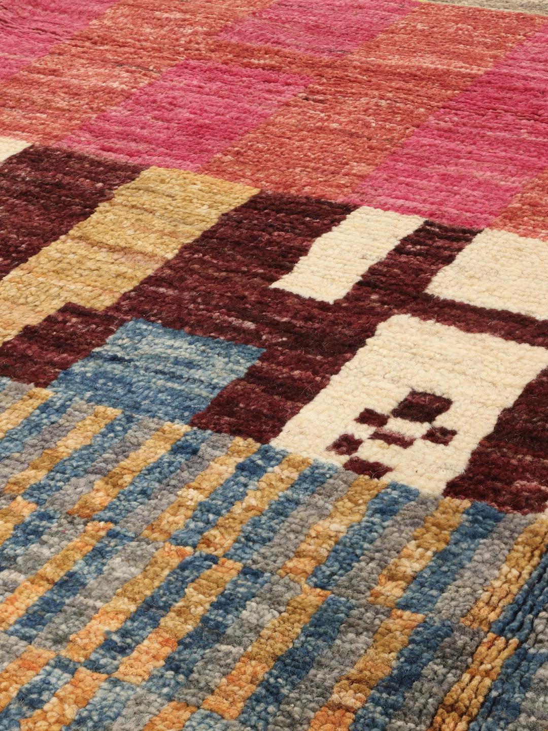 Een levendig, veelkleurig handgeknoopt tapijt met geometrische patronen uit Afghanistan.