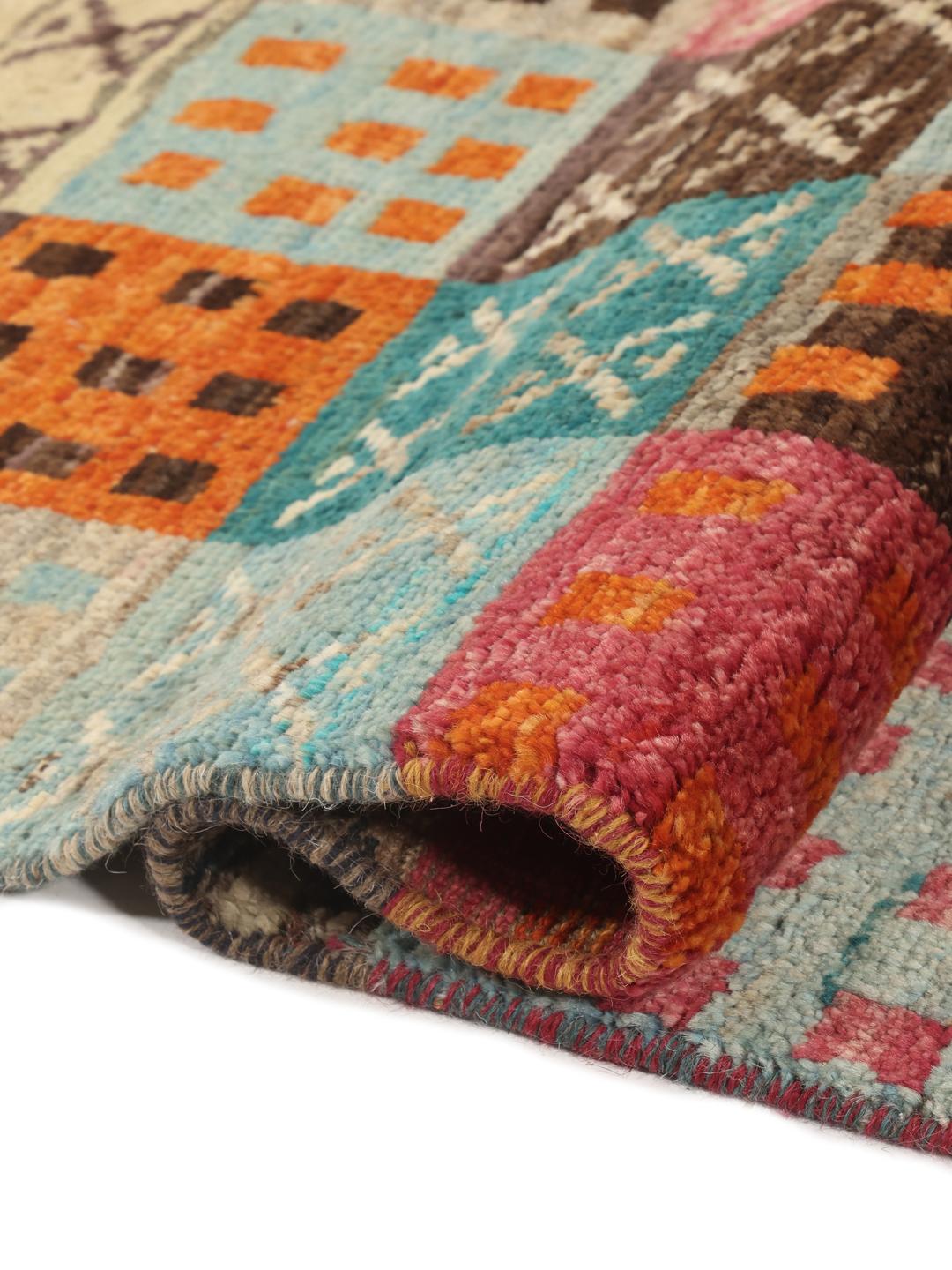 Un tapis multicolore vibrant noué à la main, originaire d'Afghanistan, avec un design patchwork géométrique.