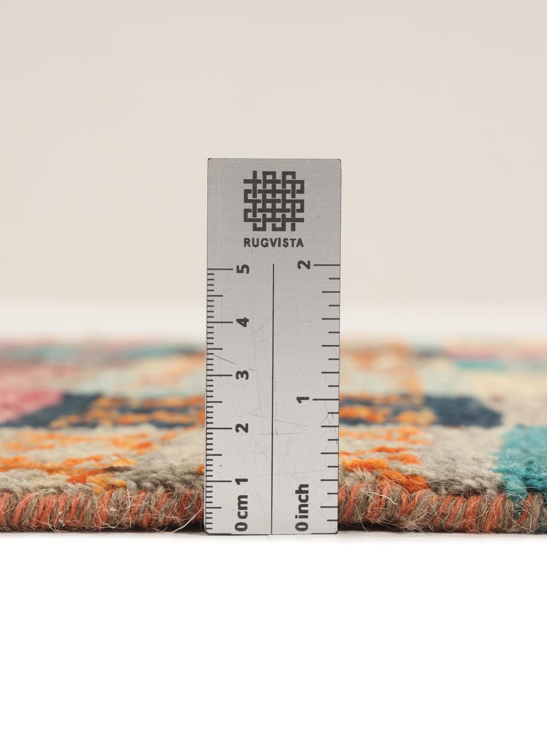 Un tapis multicolore vibrant noué à la main, originaire d'Afghanistan, avec un design patchwork géométrique.
