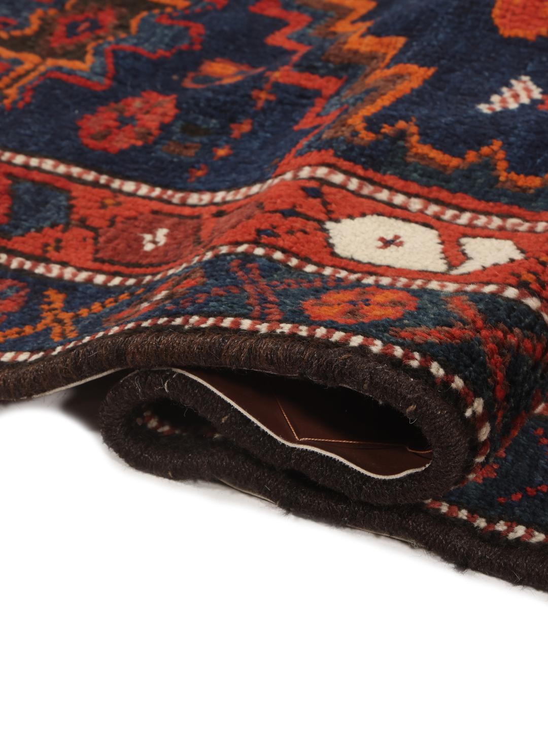 Een handgeknoopte Shiraz loper uit het Midden-Oosten met een donkerblauw en rood geometrisch ontwerp.