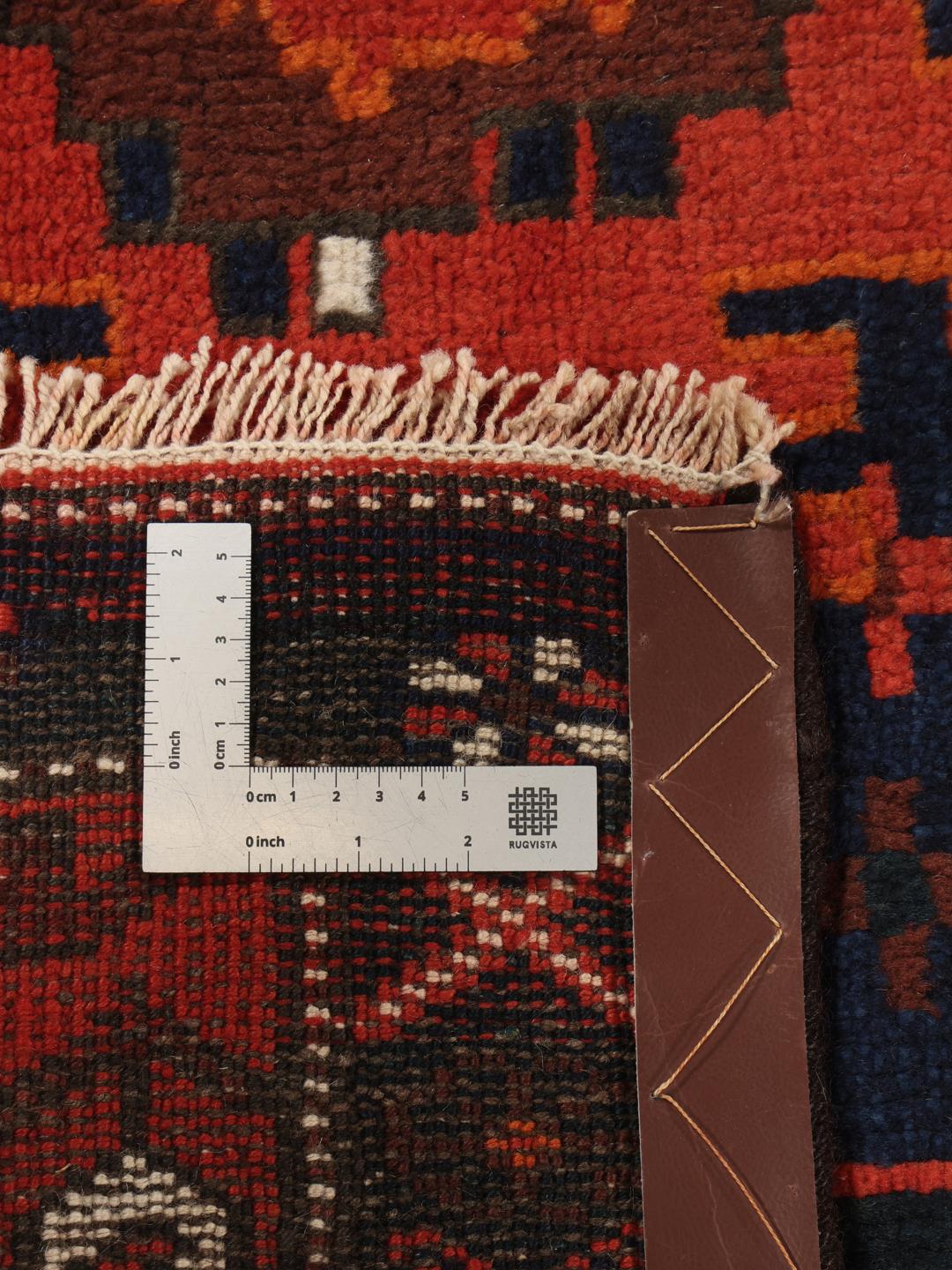 Een handgeknoopte Shiraz loper uit het Midden-Oosten met een donkerblauw en rood geometrisch ontwerp.