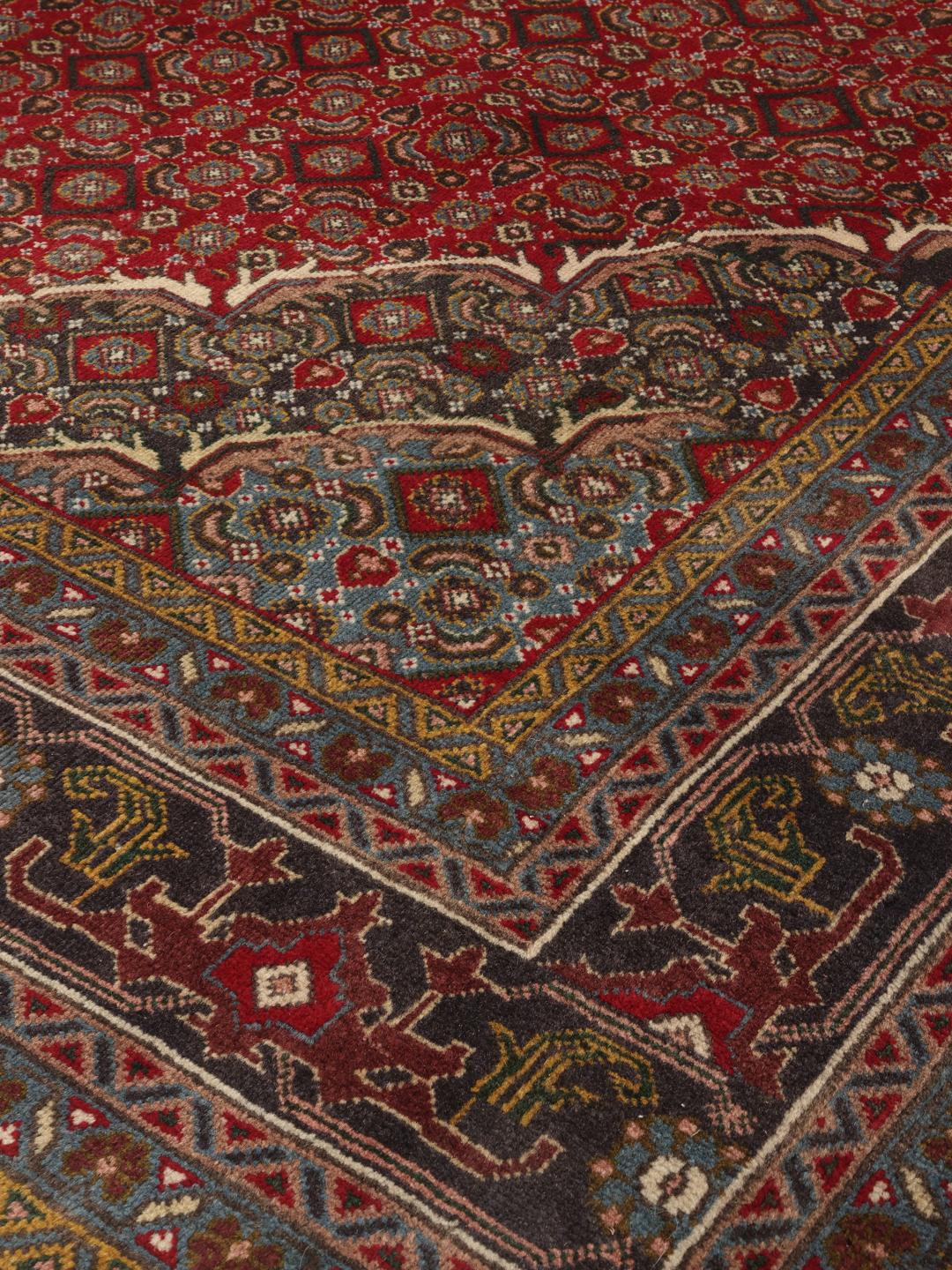 Hand-knotted Tabriz rug from the Middle East in deep red and blue tones
