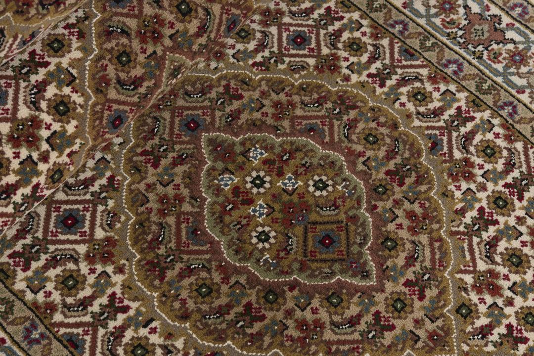 A hand-knotted Tabriz runner from India with a beige background and floral medallion patterns.