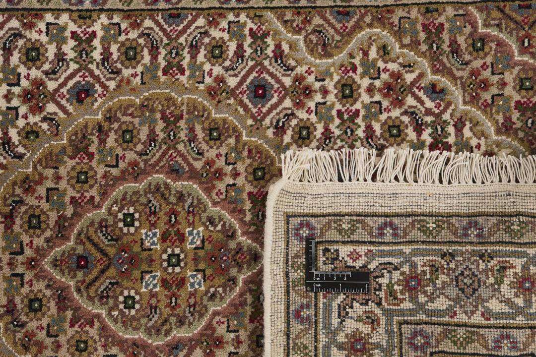 A hand-knotted Tabriz runner from India with a beige background and floral medallion patterns.