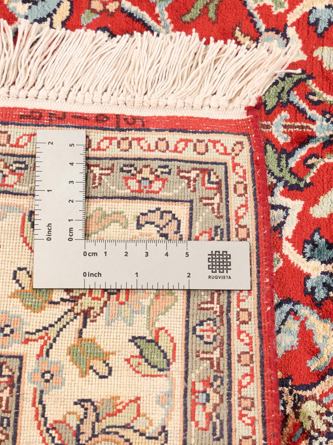 Et håndknyttet Kashmir-silketæppe fra Indien med et levende rødt felt og blomstermønstre.