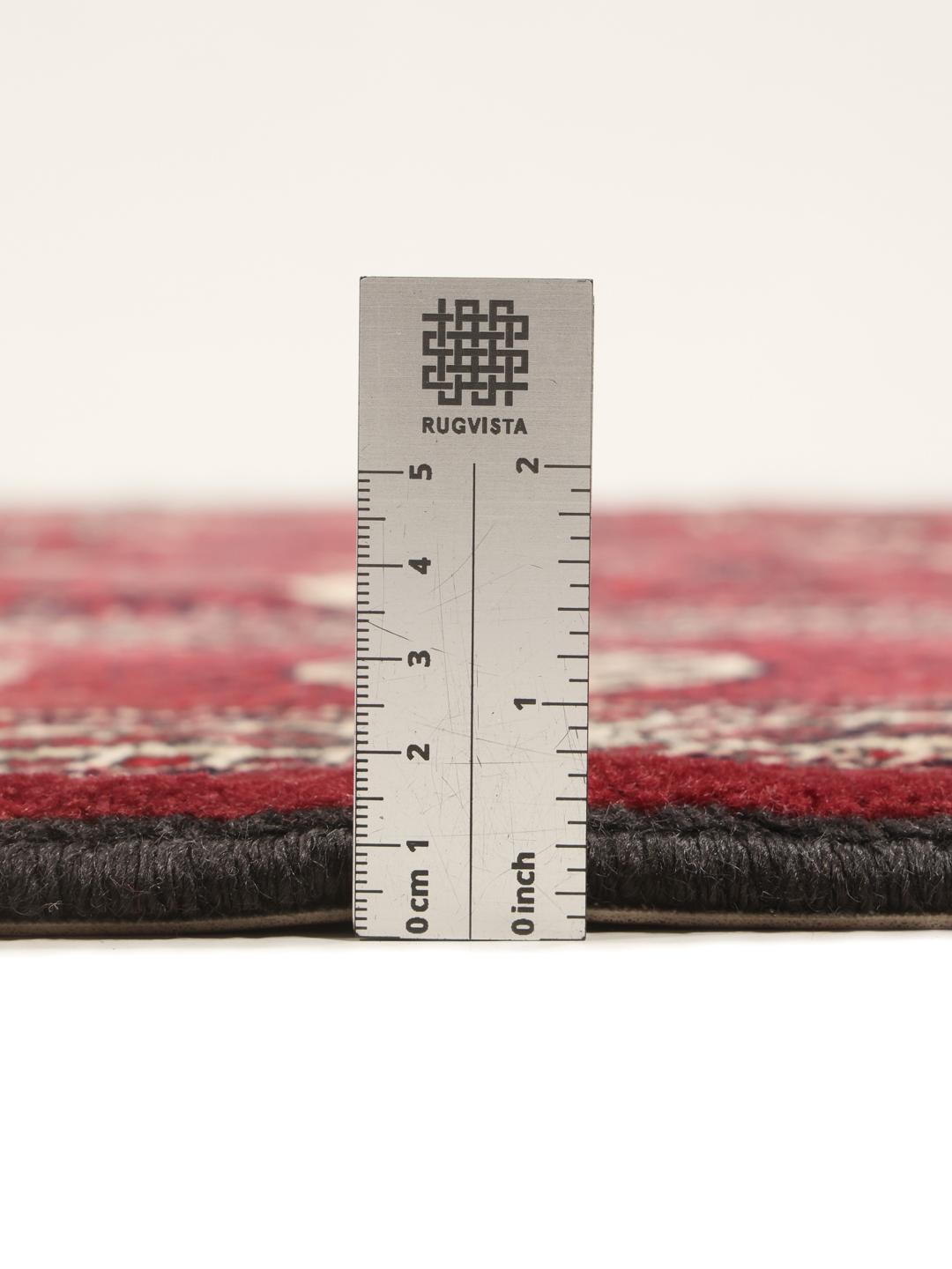 A hand-knotted Middle Eastern Turkman rug featuring deep red tones and geometric patterns.
