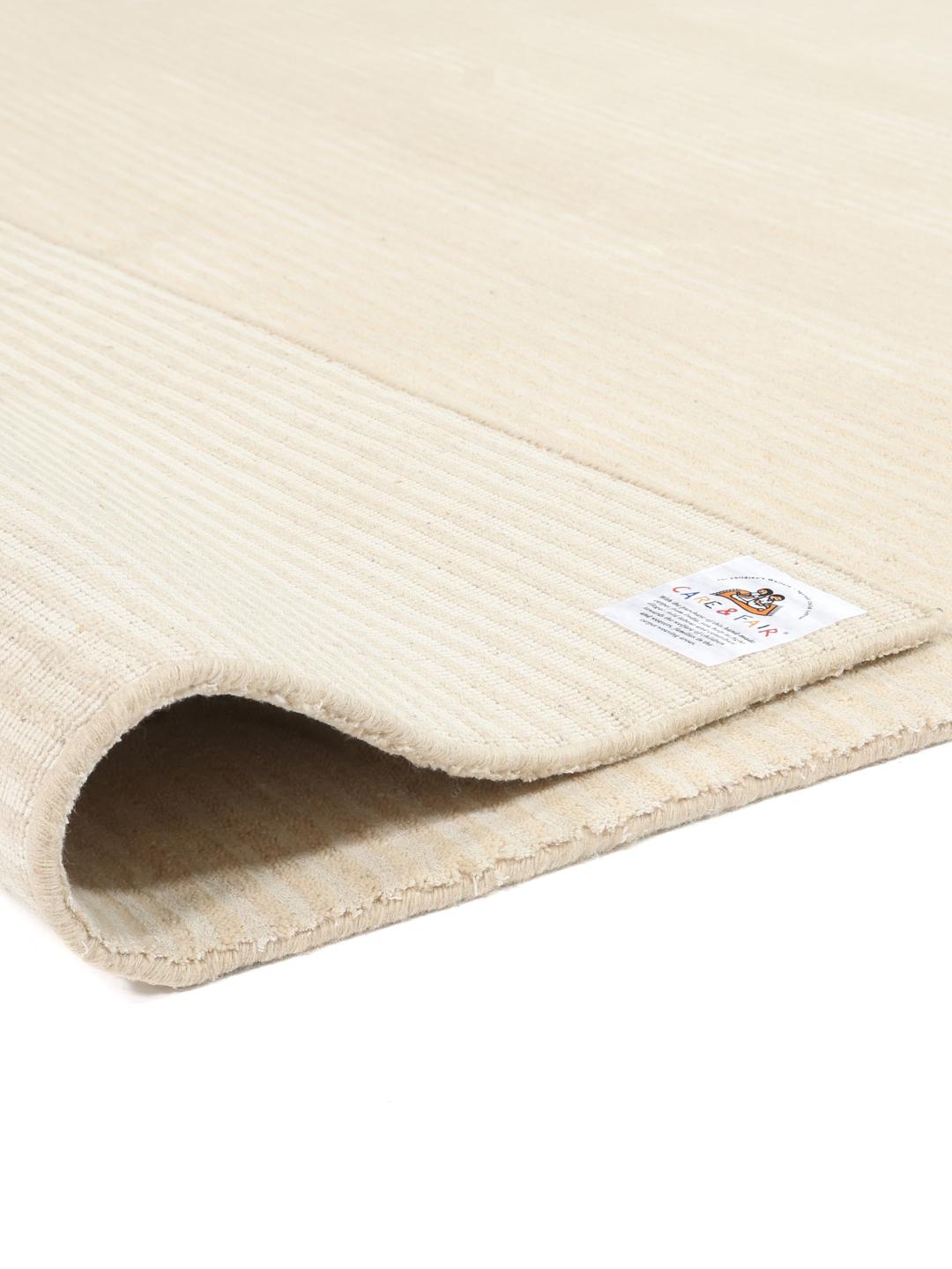 Beige tæppe med et diskret stribet mønster
