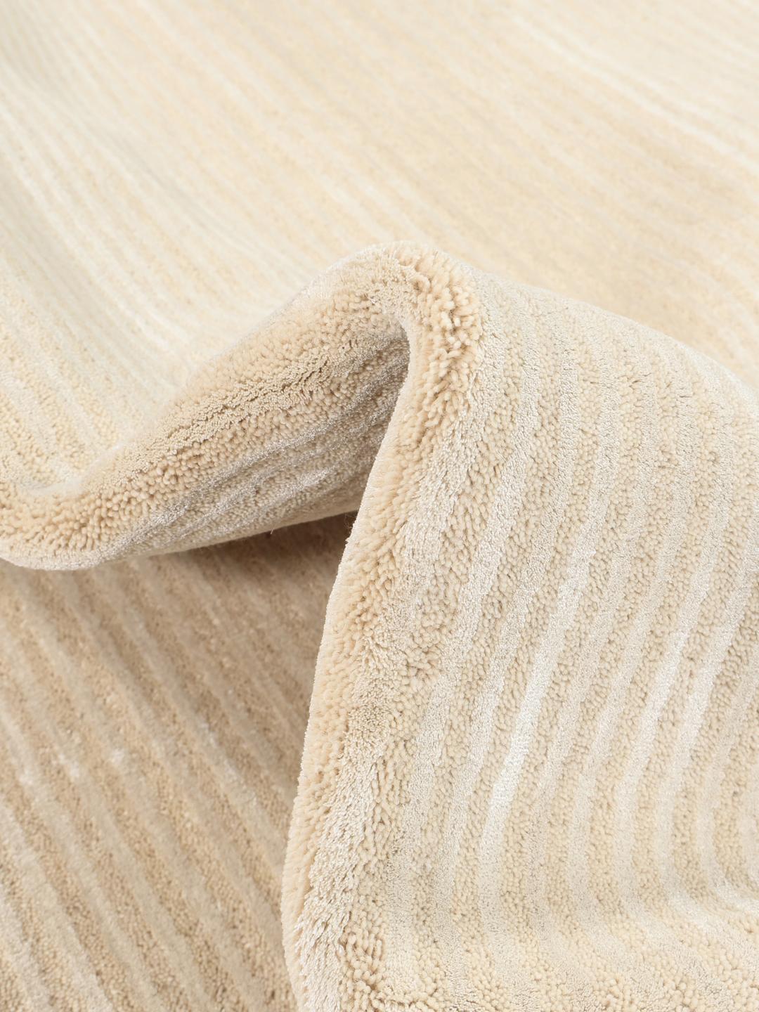 Beige tæppe med et diskret stribet mønster