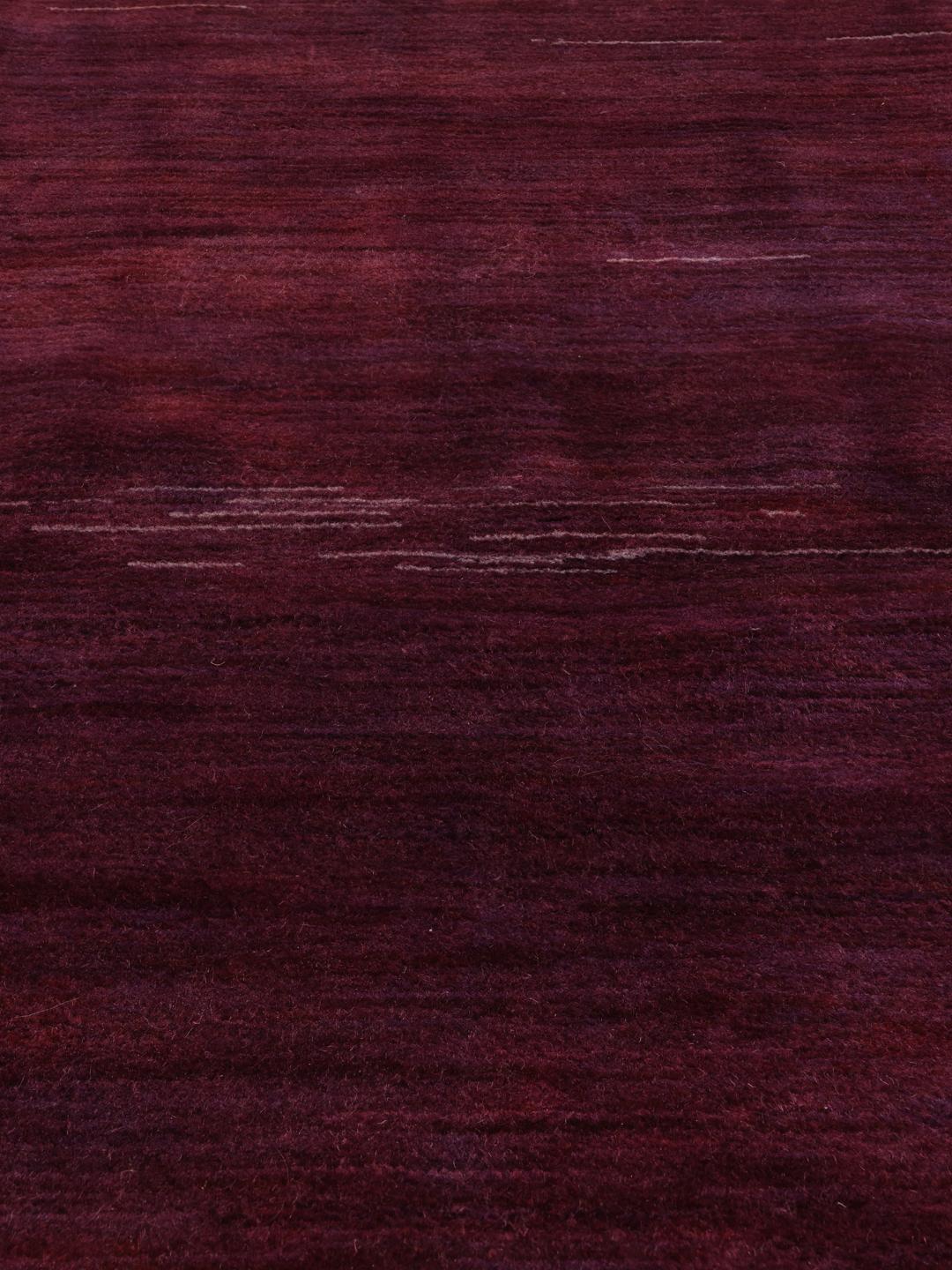 A hand-knotted Gabbeh Fine rug from the Middle East in deep purple tones.