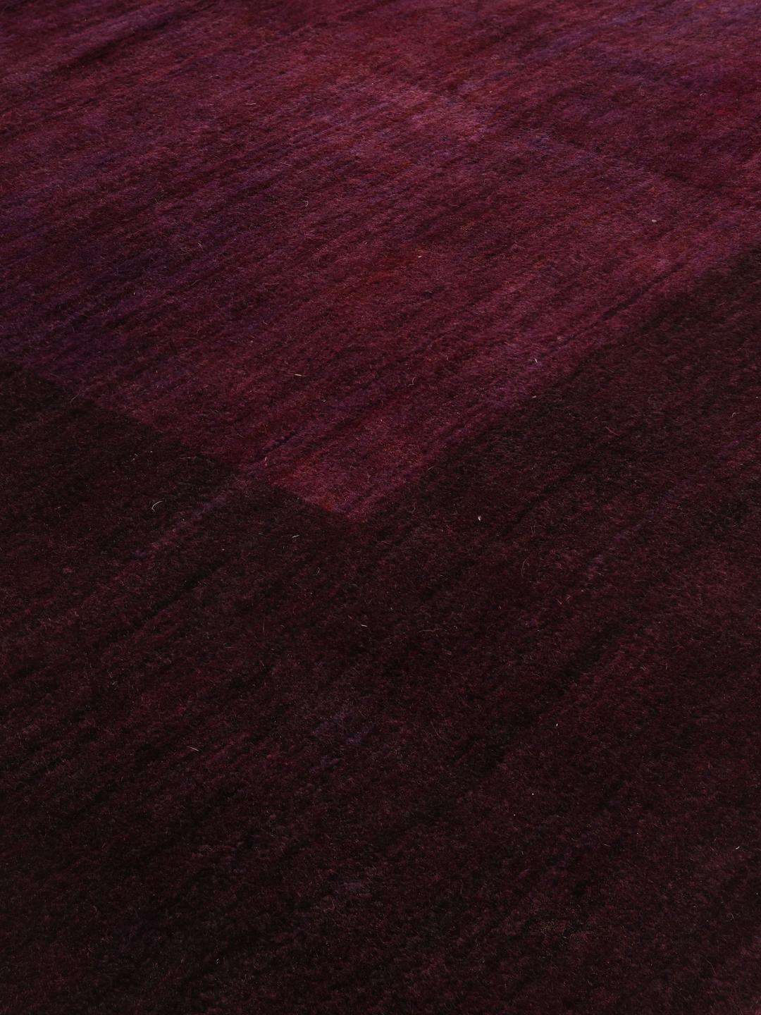 A hand-knotted Gabbeh Fine rug from the Middle East in deep purple tones.