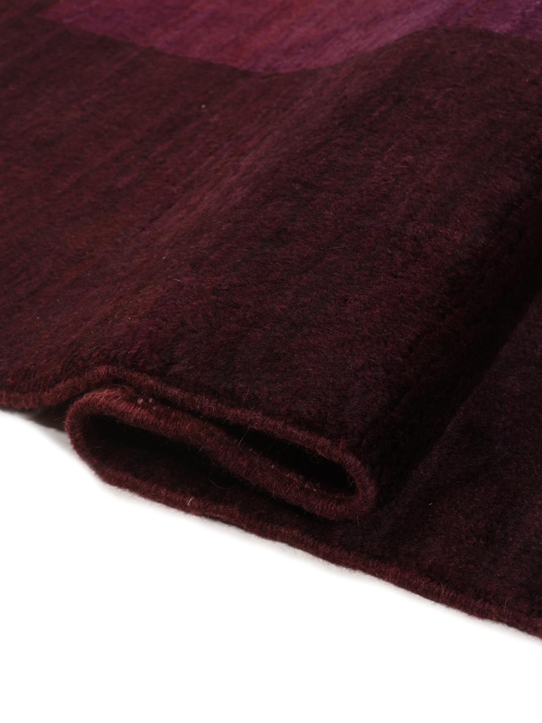 A hand-knotted Gabbeh Fine rug from the Middle East in deep purple tones.