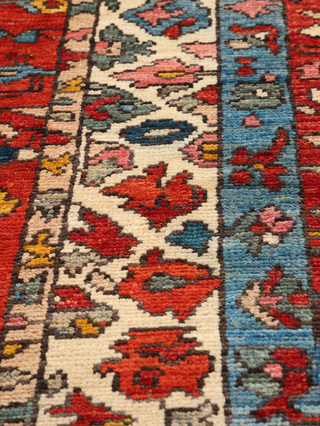 Tapis Kazak afghan noué à la main avec un design géométrique vibrant et des tons bleu et rouge.