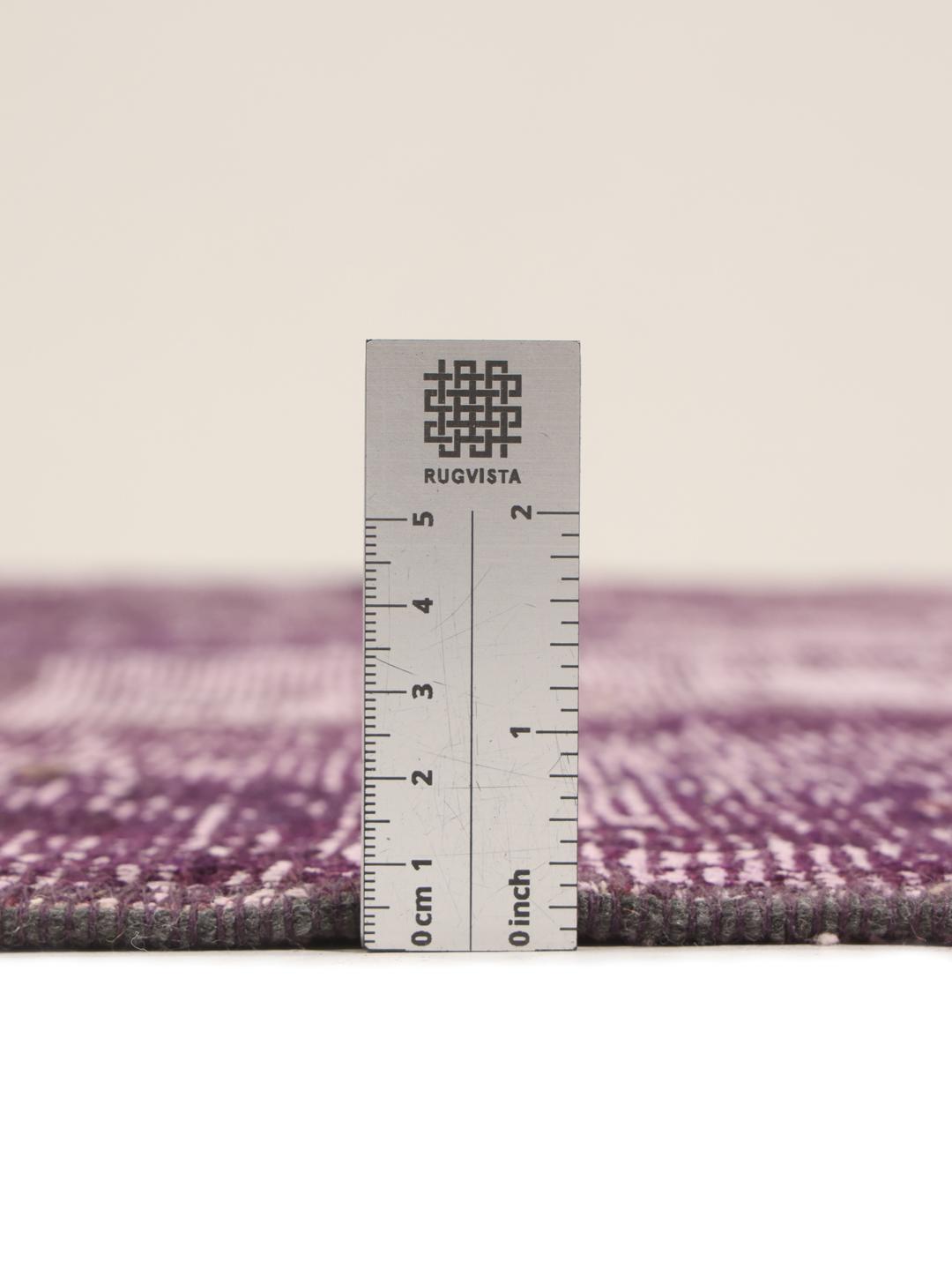 Een vierkant patchwork vloerkleed uit het Midden-Oosten in paarse tinten.
