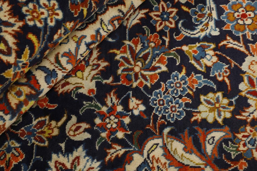 Een handgeknoopt Najafabad-tapijt uit het Midden-Oosten met een marineblauw veld en sierlijke bloemmotieven.