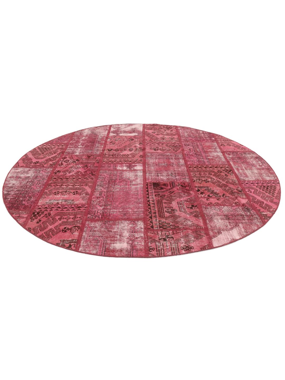 Een rond rood patchwork tapijt uit het Midden-Oosten met geometrische en florale patronen