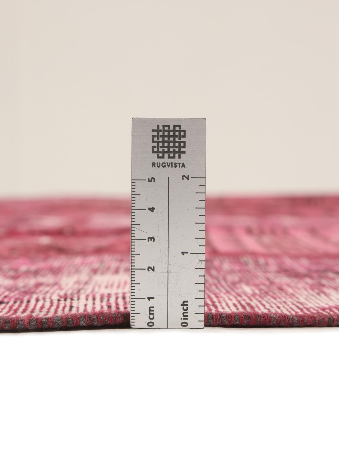 Een rond rood patchwork tapijt uit het Midden-Oosten met geometrische en florale patronen
