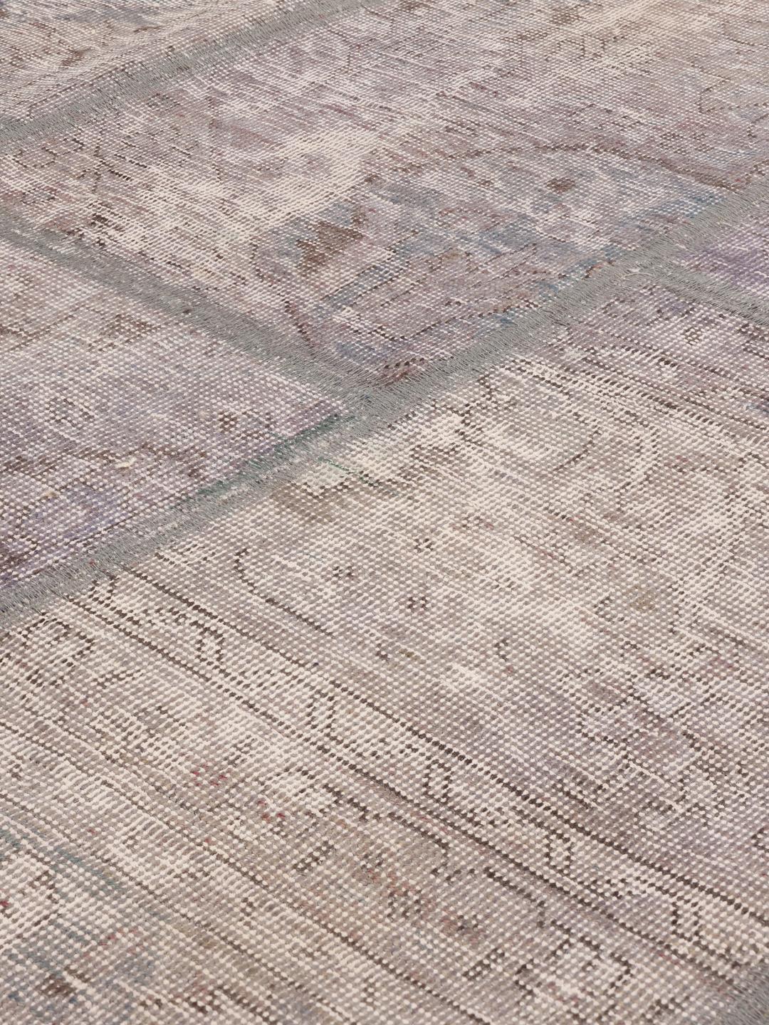 Rundt patchwork-tæppe med vintage designelementer fra Mellemøsten i grå nuancer