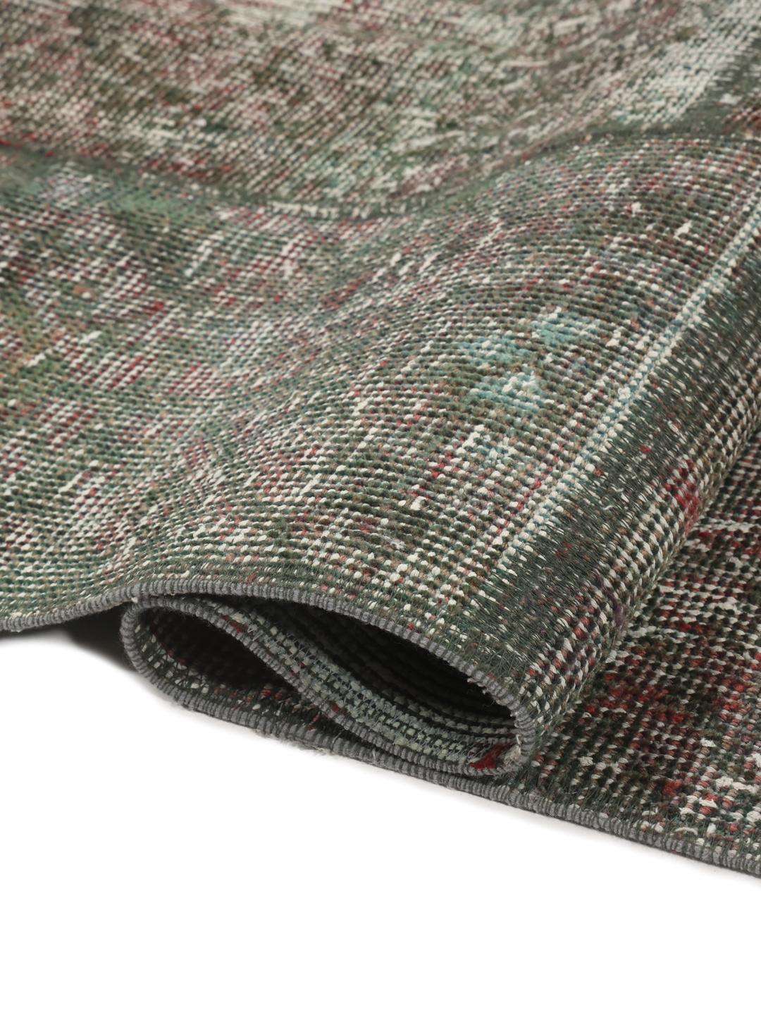 Et unikt rektangulært patchwork-tæppe med en mørkegrå og rød palet med oprindelse fra Mellemøsten.