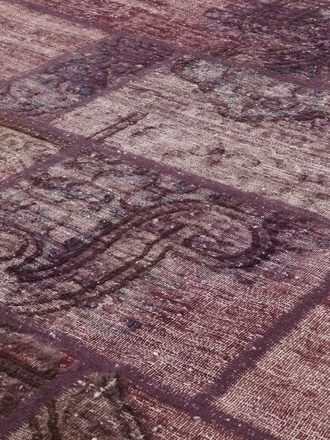 A unique patchwork rug from the Middle East featuring a dark-red colour palette