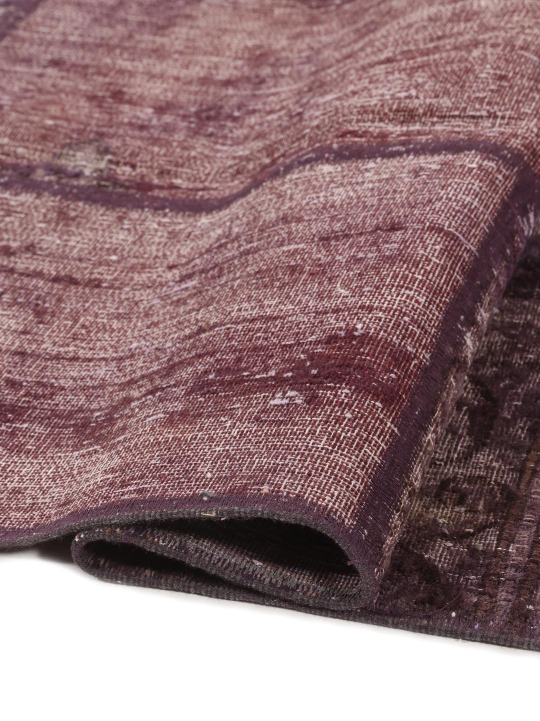 A unique patchwork rug from the Middle East featuring a dark-red colour palette