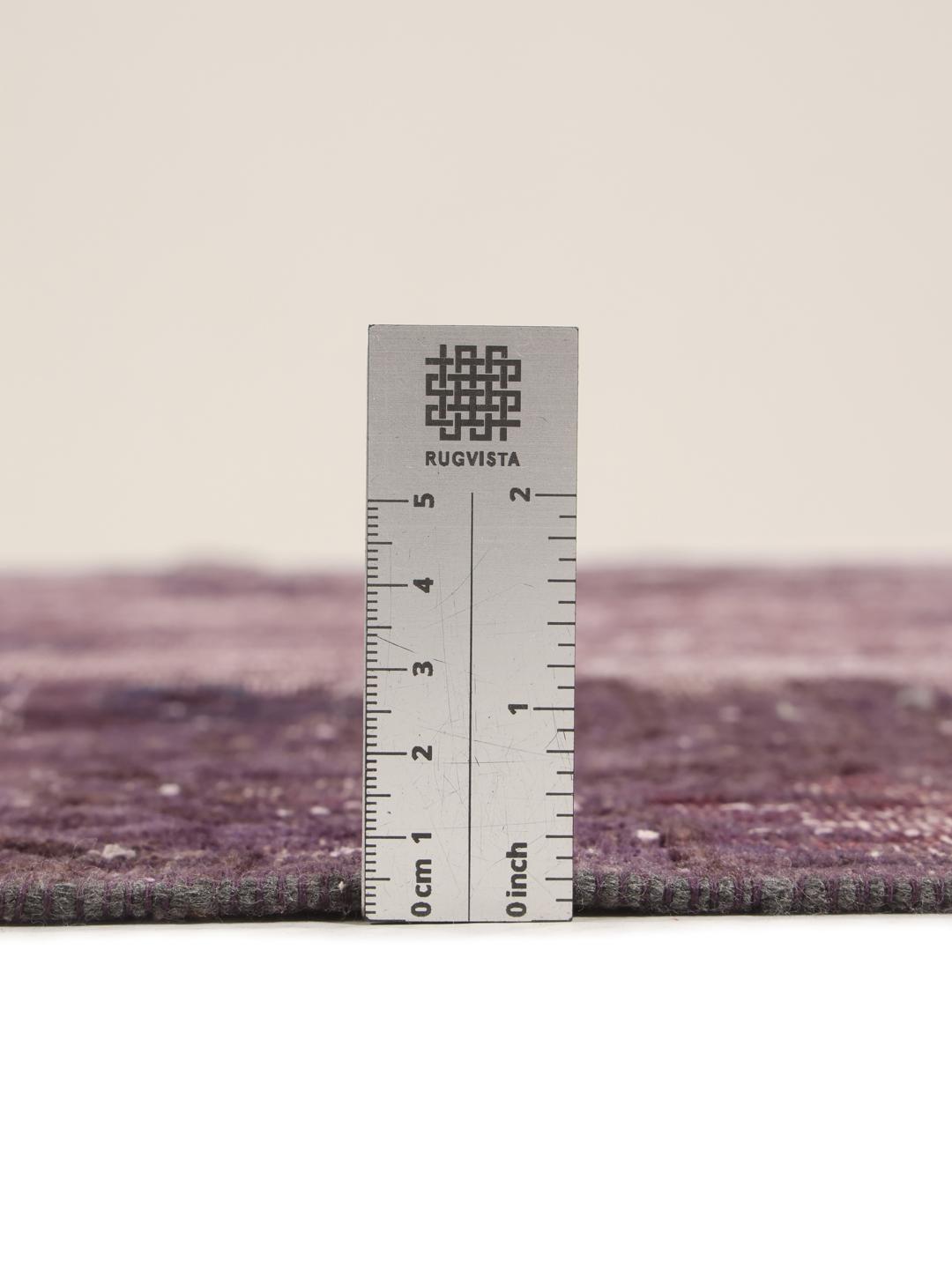A unique patchwork rug from the Middle East featuring a dark-red colour palette