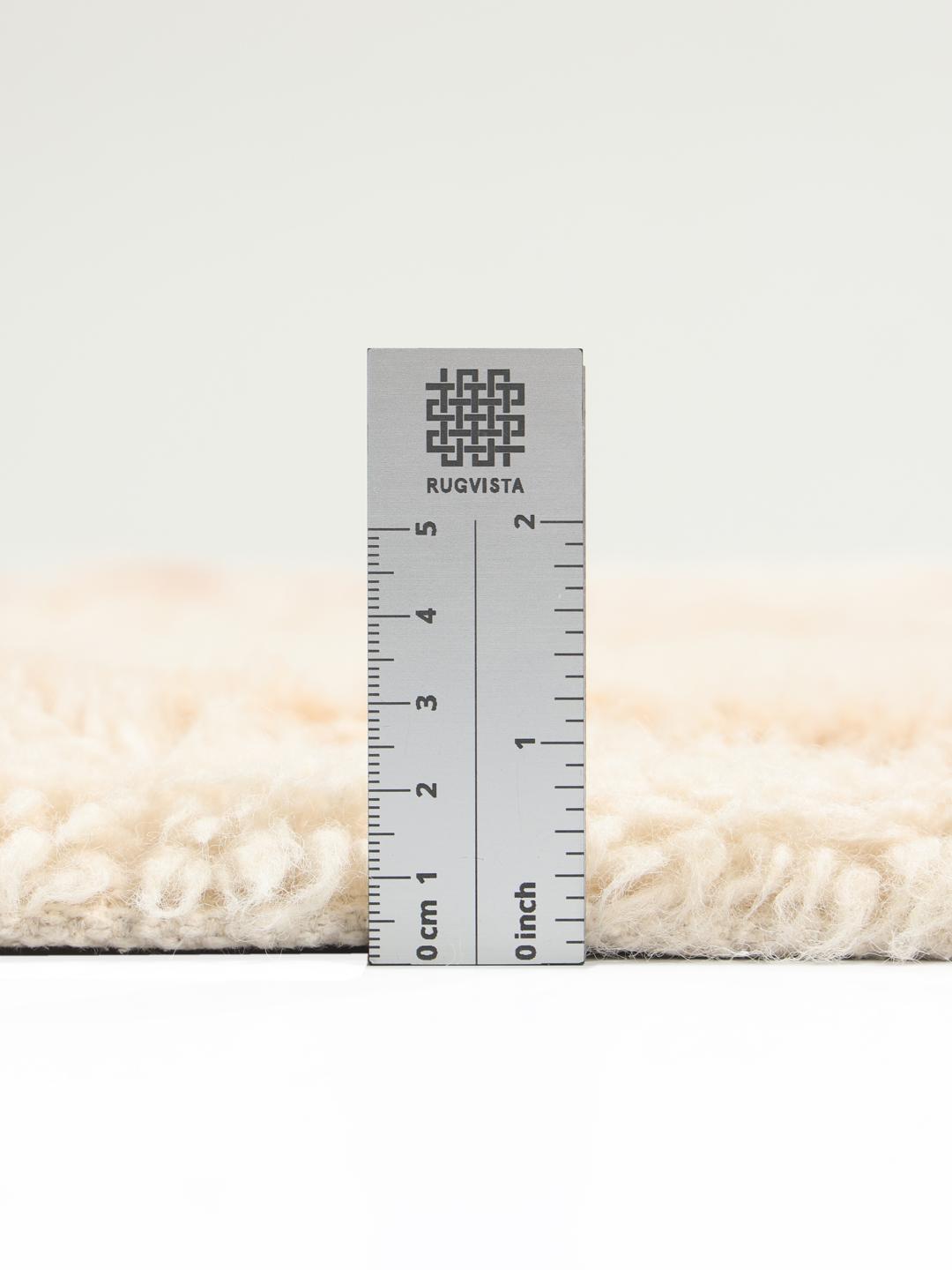 Beige tæppe med blød luv og et diskret flerfarvet ternet design