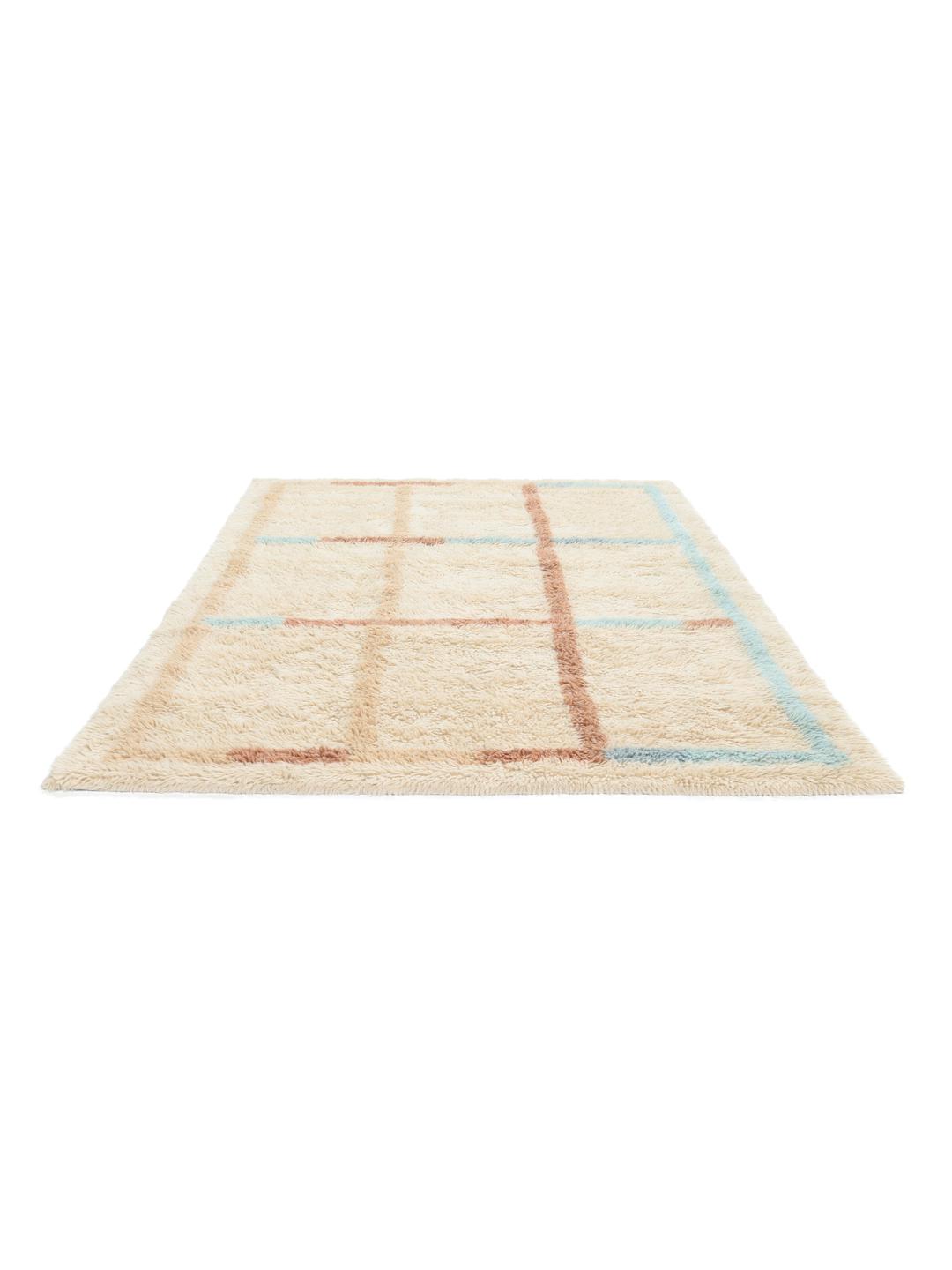 Beige tæppe med blød luv og et diskret flerfarvet ternet design
