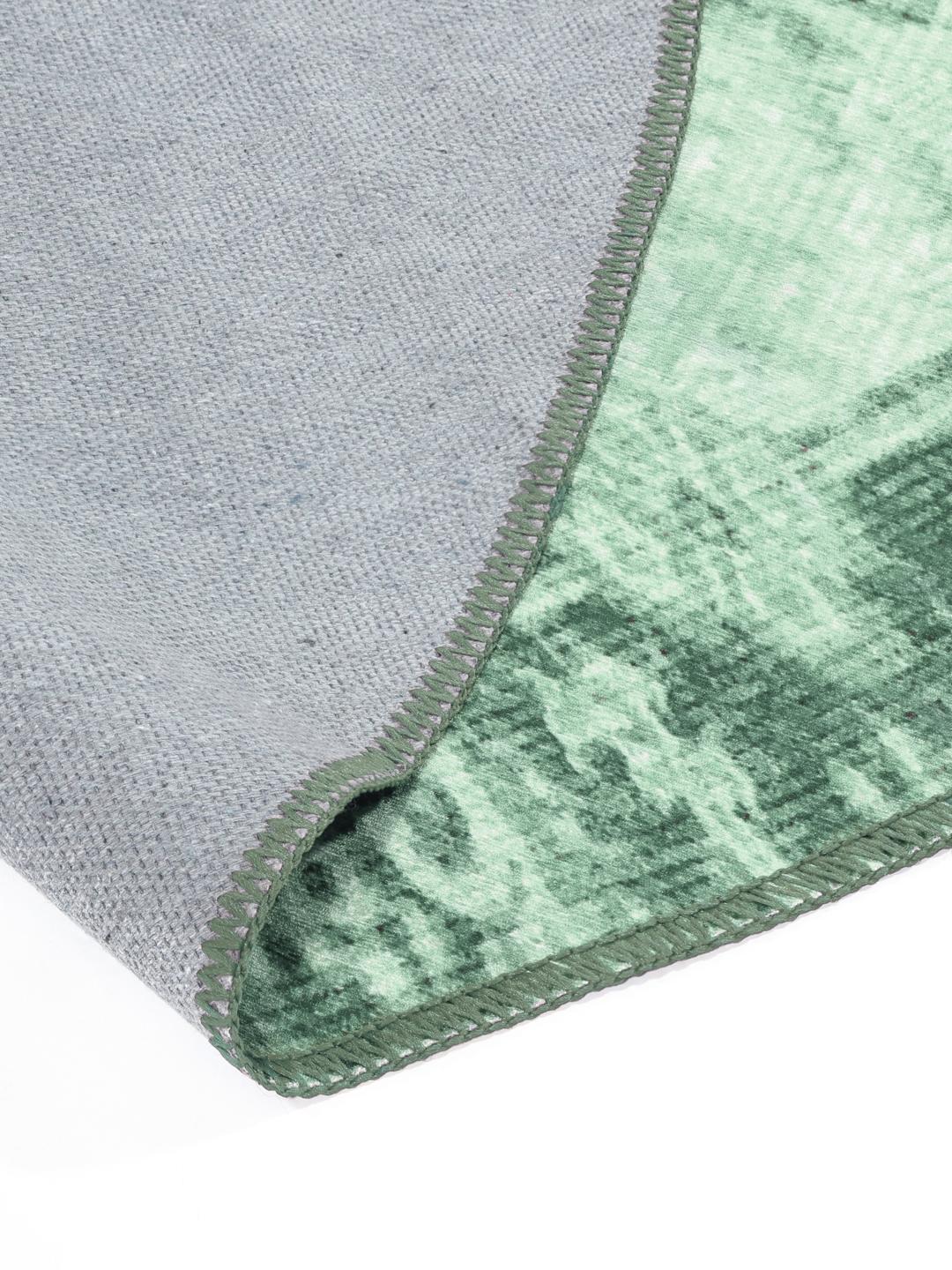 Rond groen vloerkleed met een verweerd patroon
