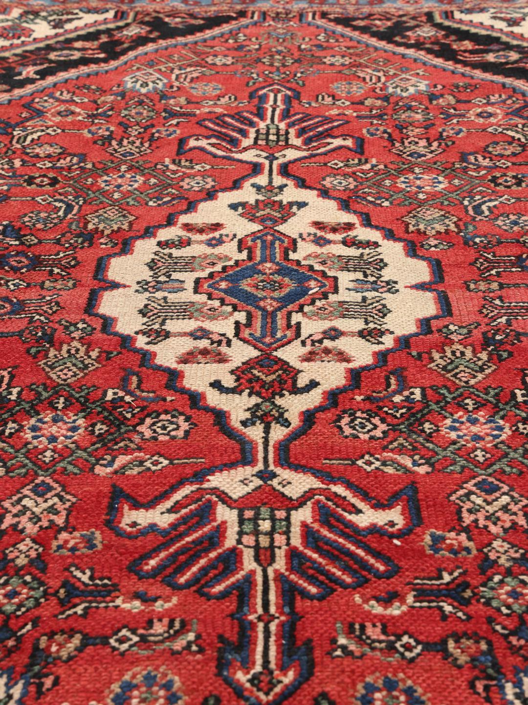 Met de hand geknoopt Hamadan-tapijt uit het Midden-Oosten met een rood medaillon en blauwe accenten