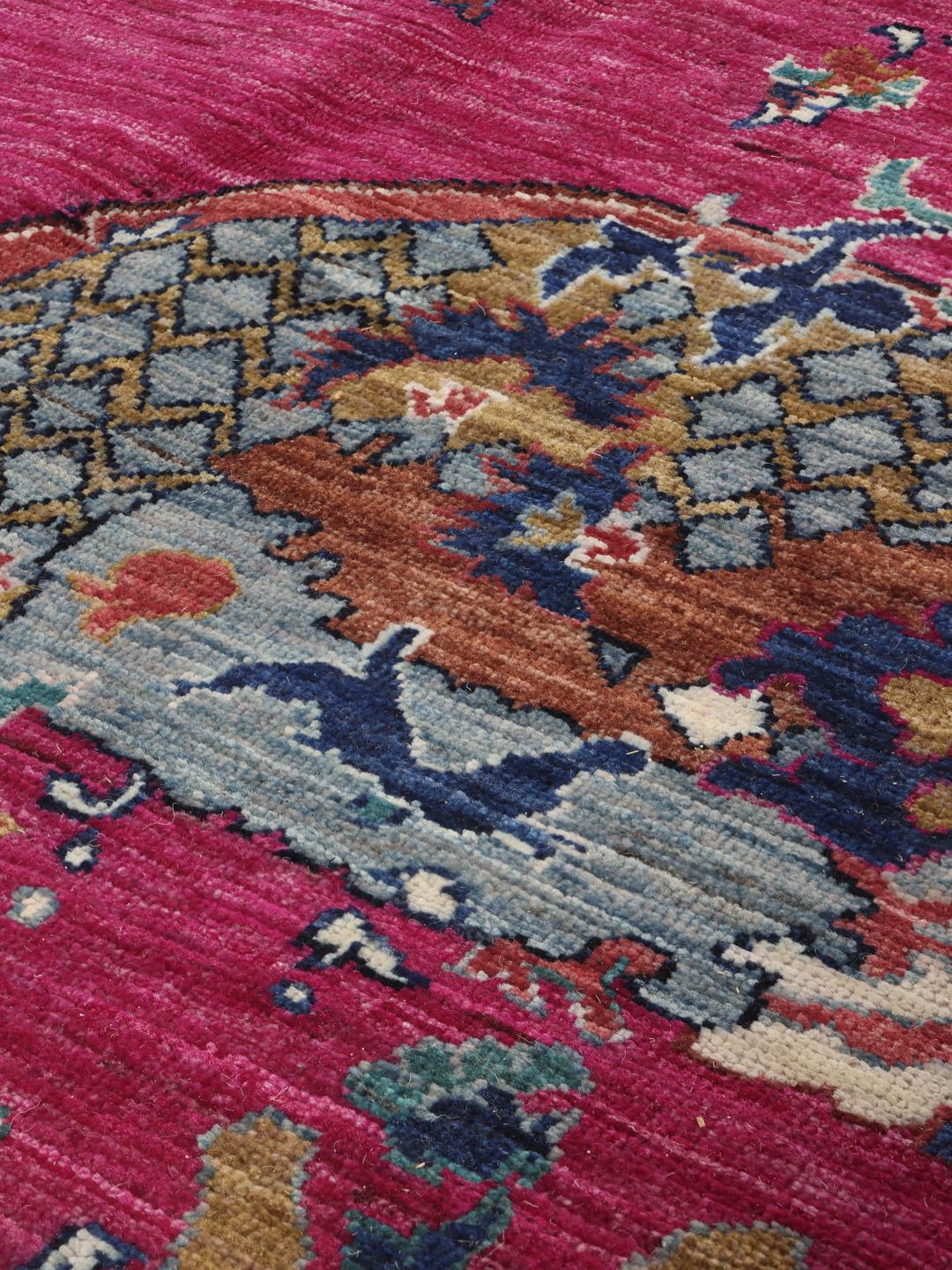 Tapis Kazak Ariana noué à la main venant d'Afghanistan avec un fond magenta et des motifs ornés.