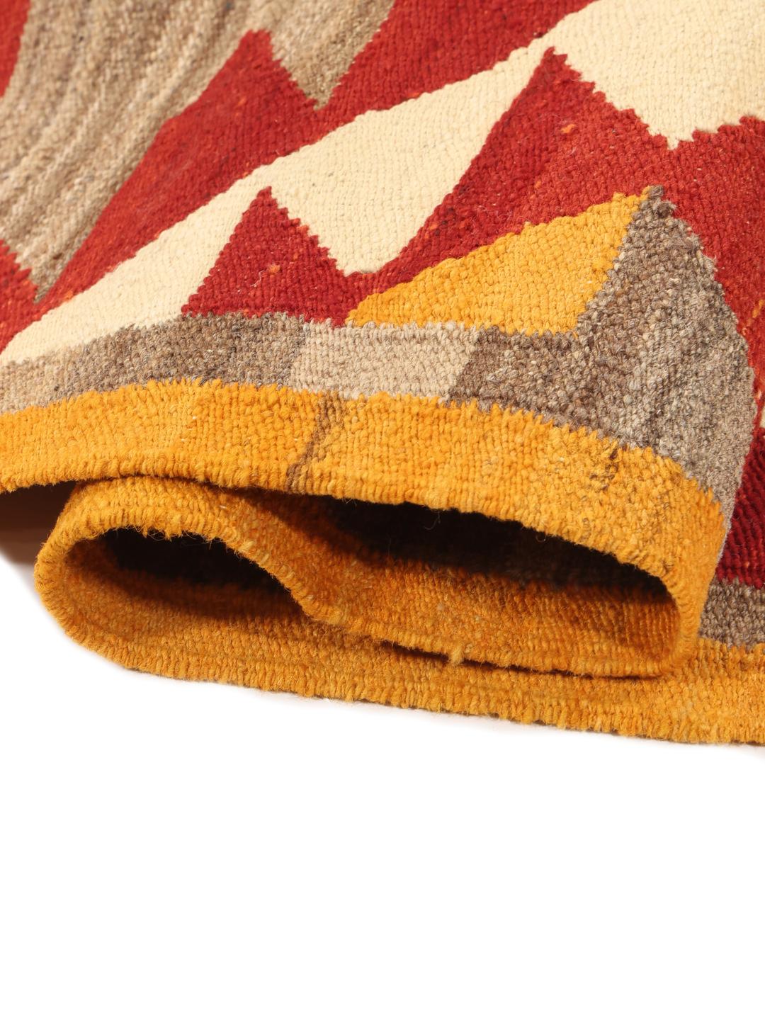Hand-woven Afghan kilim rug with vibrant geometric patterns in red, yellow, and beige.