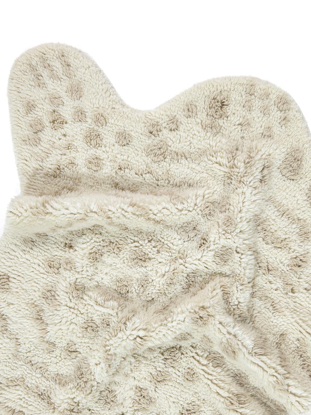 Onregelmatig gevormd wit en beige tapijt met een zachte pooltextuur